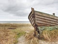 Abandoned wrecked boat stuck in sand. Old wooden boat on the sandy shore Royalty Free Stock Photo