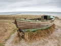 Abandoned wrecked boat stuck in sand. Old wooden boat on the sandy shore Royalty Free Stock Photo