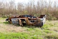 Abandoned wrecked and rusted car on overgrown lot in the suburbs