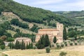 Abbey of Sant Antimo Abbazia di Sant`Antimo surrounded by cypresses and olive trees. Castelnuovo dell`Abate, Tuscany, Italy Royalty Free Stock Photo