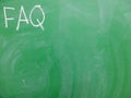 Abbreviation FAQ frequently asked questions written on a green, relatively dirty chalkboard by chalk. Located in the upper left