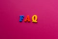 Abbreviation FAQ from plastic magnetic letters on pink background Royalty Free Stock Photo