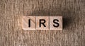 The abbreviation lettering of the word IRS Internal Revenue Service on wooden cubes on a brown background Royalty Free Stock Photo