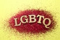 Abbreviation LGBTQ with glitters on color background