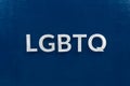 The abbreviation lgbtq - lesbian, gay, bisexual, transgendered, and queer laid with white letters on dark blue flat background