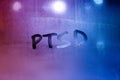 abbreviation ptsd - post traumatic stress disorder - handwritten on night wet window glass Royalty Free Stock Photo
