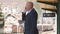 Businessman Talking to Mobile Phone in a Train Station Royalty Free Stock Photo