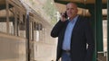 Businessman Talking to Mobile Phone in a Train Station Royalty Free Stock Photo