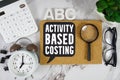 ABC Activity Based Costing text with Calculator, alarm clock and magnifying glass on marble background Royalty Free Stock Photo