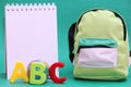 ABC-colored letters of the English alphabet next to a toy globe and a Notepad. School bag Royalty Free Stock Photo