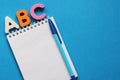 ABC-the first letters of the English alphabet on a blue background. Notebook and pen. Empty space for text. Learn foreign Royalty Free Stock Photo