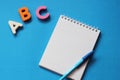 ABC-the first letters of the English alphabet on a blue background. Notebook and pen. Empty space for text. Learn foreign Royalty Free Stock Photo
