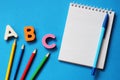 ABC-the first letters of the English alphabet on a blue background. Notebook and pen. Empty space for text. Learn foreign Royalty Free Stock Photo