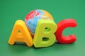 ABC-the first letters of the English alphabet and small toy globe on a green background Royalty Free Stock Photo