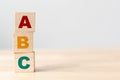 ABC letters alphabet on wooden cube blocks in pillar form on wood table Royalty Free Stock Photo