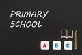 Abc letters and chipboard miniature on blackboard with text primary school