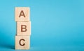 ABC letters of wooden blocks in pillar form on blue background Royalty Free Stock Photo