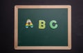 Abc text on green board with wooden frame, black background Royalty Free Stock Photo