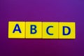 ABCD spelling on yellow plastic cubes