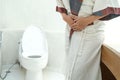 Abdominal pain woman holds her stomach with her hand. She has stomachache from diarrhea. Constipation concept. bathroom toilet Royalty Free Stock Photo