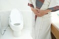 Abdominal pain woman holds her stomach with her hand. She has stomachache from diarrhea. Constipation concept. bathroom toilet Royalty Free Stock Photo