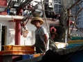 Fisherman in traditional head gear on working boat