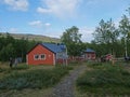 Abiskojaure, Norrbotten, Sweden, Agust 23, 2019: group of hikers resting at red AbiskoJaure STF hut. Green hills, birch forest and