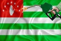 ABKHAZIA flag Close-up shot on waving background texture with Fuel pump nozzle in hand. The concept of design solutions. 3d