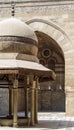 Ablution fountain at historic Sultan Barquq Mosque with huge arch in background, Cairo, Egypt