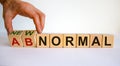 Abnormal or new normal. Male hand turns cubes and changes the words `abnormal` to `new normal`. Covid-19 postpandemic concept. Royalty Free Stock Photo