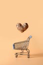 Abnormal potato in shape of heart flying into grocery cart. Concept love organic homegrown ugly vegetables