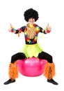 Aborigine woman sitting on fitness ball with thumb up on white