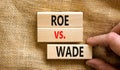 Abortion process Roe versus Wade symbol. Concept words Roe versus Wade on wooden blocks. Lawyer hand. Beautiful canvas table