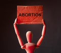 Abortion word on placard in hands in red light Royalty Free Stock Photo