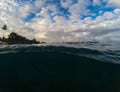 Above and below waterline in tropical seashore. Dark seawater and sunny sky. Royalty Free Stock Photo