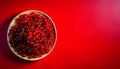 Top view of a red worktop with delicious currants on a plate