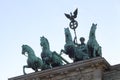 Above the Brandenburg Gate stands the Goddess of Victory in a chariot drawn by four horses heading towards the city. Royalty Free Stock Photo