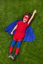 Excited superhero flying over lawn