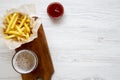 From above french fries with ketchup and cold beer over white wooden background. Top view.