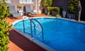 Above ground pool sunken below ground and surrounded by decking