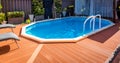 Above ground pool sunken below ground and surrounded by decking