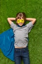 Confident superhero lying on lawn Royalty Free Stock Photo