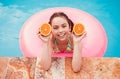Cheerful girl with fresh orange swimming in pool Royalty Free Stock Photo