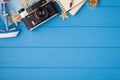 Above photo of camera map starfish ship notepad pen and compass isolated on the blue wooden background with copyspace