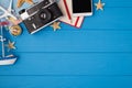 Above photo of camera starfishes notepad pencil map plane compass ship and phone isolated on the blue wooden background with empty