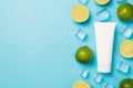 Above photo of pile of limes cubes of ice drops mint and tube of cream isolated on the blue background with blank space Royalty Free Stock Photo