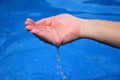 Above the pool from one human hand flowing water