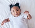 Above, portrait and baby relax in bed, happy and content after waking up in her home. Face, toddler and girl smile in a Royalty Free Stock Photo