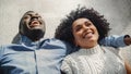 Above Portrait of Multiethnic Couple Laying Down on the Carpet and Talking, Dreaming and Imagining Royalty Free Stock Photo