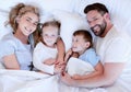 Above portrait view of a young family lying in bed. Married couple enjoying free time with their son and daughter at Royalty Free Stock Photo